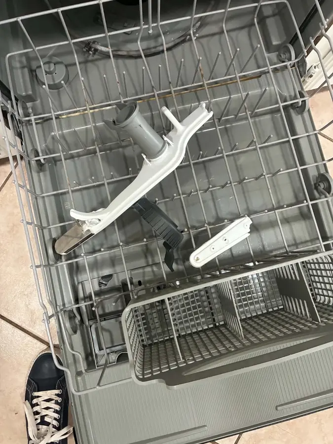 Dishwasher Upper Spray Arm Replacement: We removed a cracked upper spray arm and its feed tube from the rack