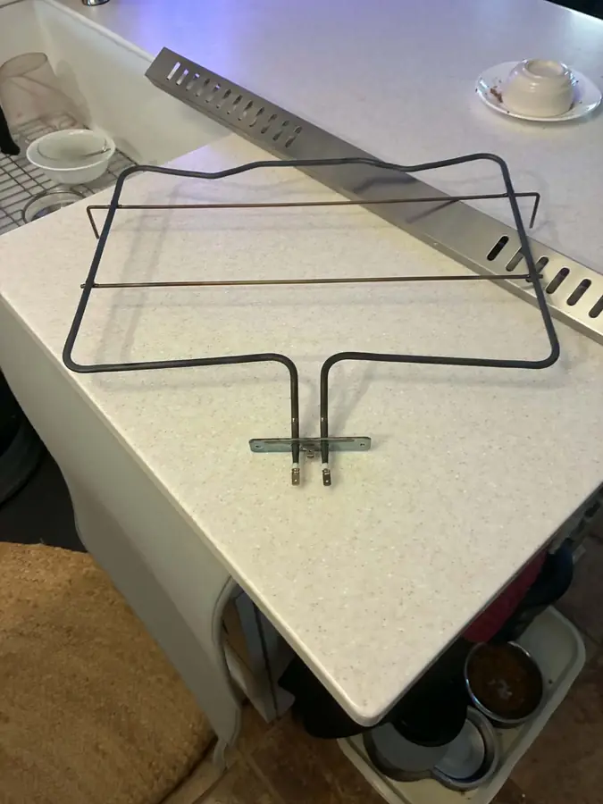 Oven Bake Element Replacement: The burnt-out bake element, removed from an electric oven