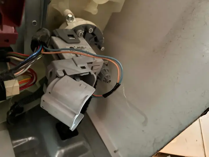 Washer Drain Pump Installation: A new drain pump, mounted and wired inside the washer cabinet